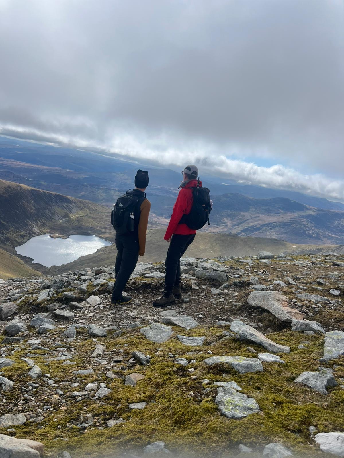 Two people looking out over a mountain lake