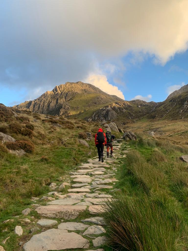 Two people walking up a mountain path